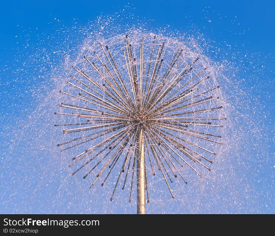 Fountain as dandelion on a blue sky background. Fountain as dandelion on a blue sky background