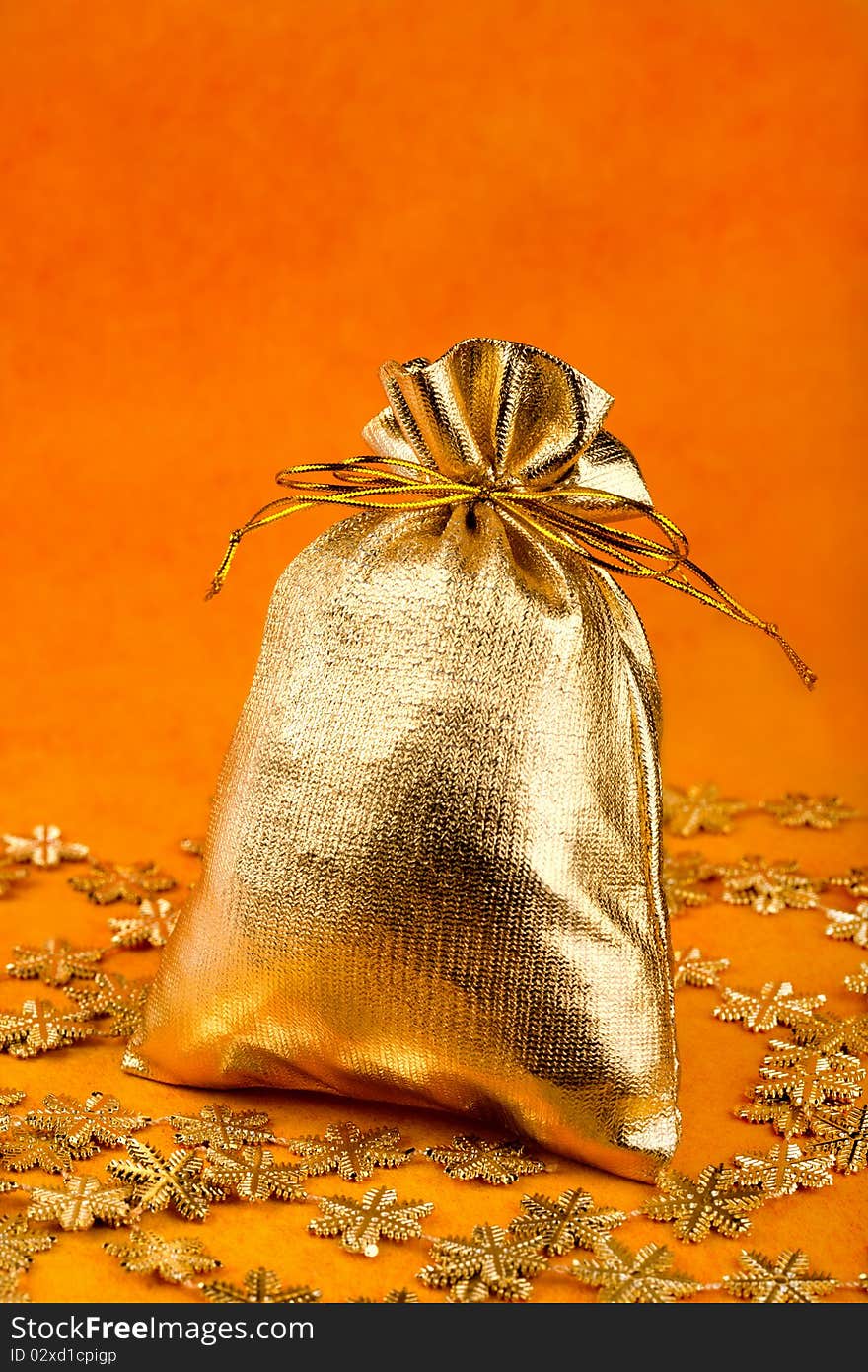 Golden gift sack and golden snowflakes