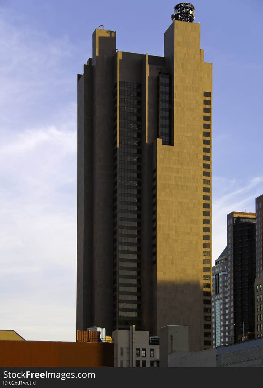 A skyscraper among other business buildings in beautiful sunlight.