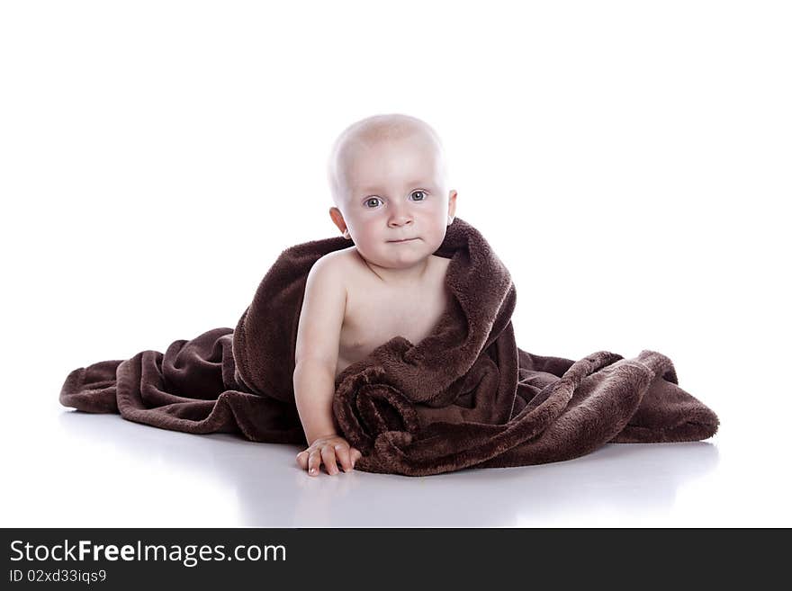 Beautiful baby under a brown towel on white background