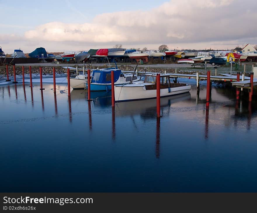 Yachts and sail boats moored to docks in a marina / sailing background image. Yachts and sail boats moored to docks in a marina / sailing background image