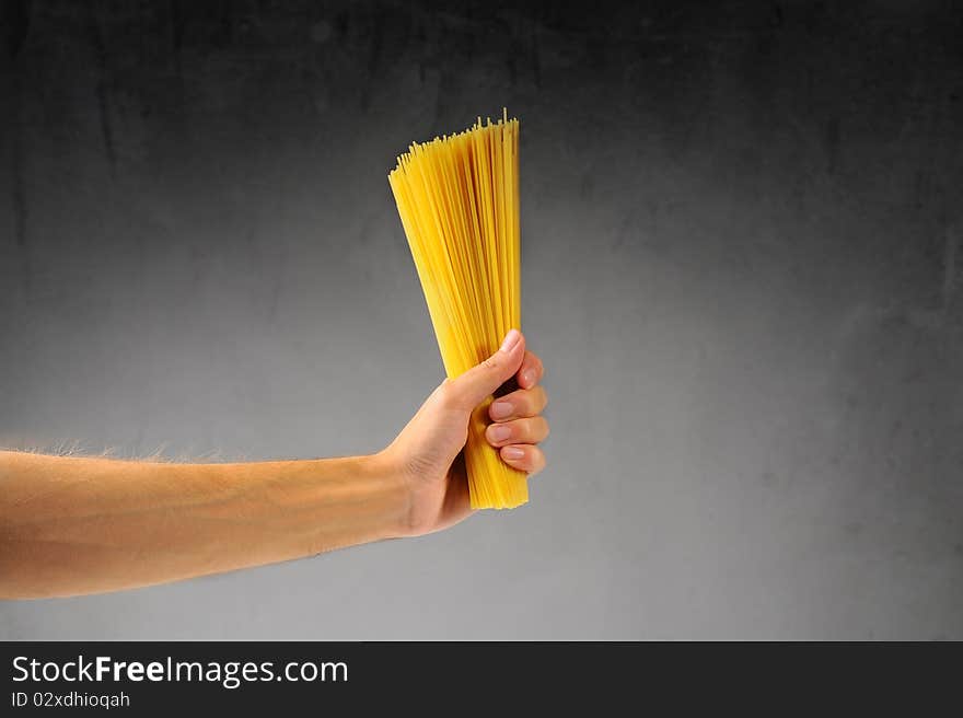 Man's hand holding a handful of spaghetti