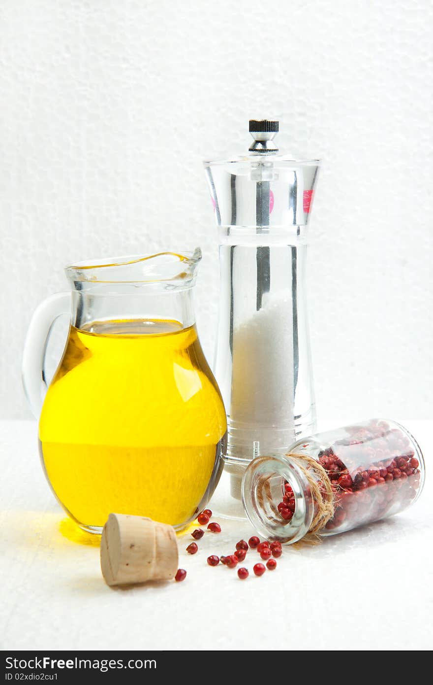 Olive oil with salt and pepper on a white texture background