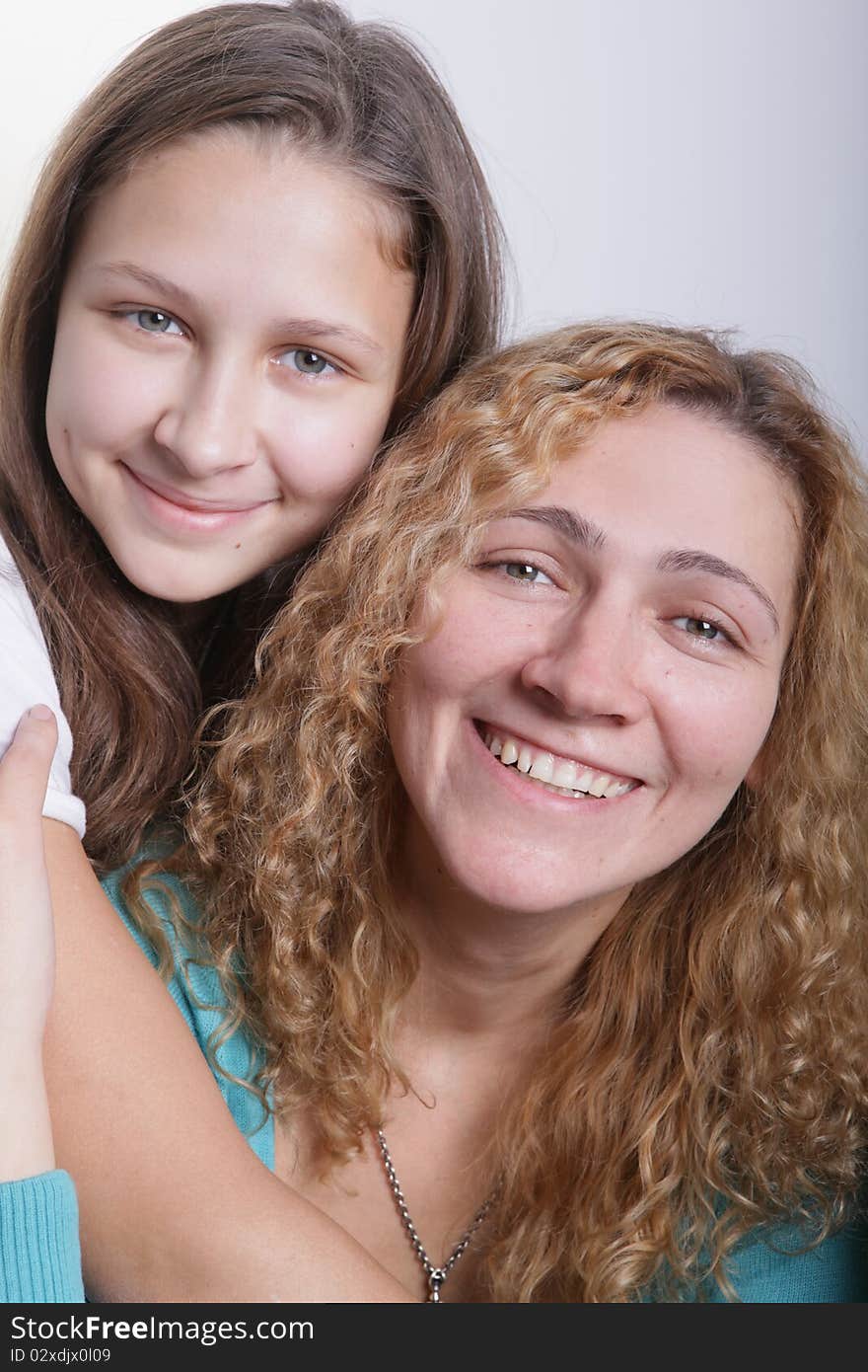 A portrait of mother and duaghter on a light background. A portrait of mother and duaghter on a light background