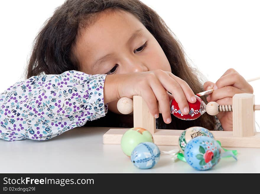 Paint easter egg, girl doing her creative hobby against white background