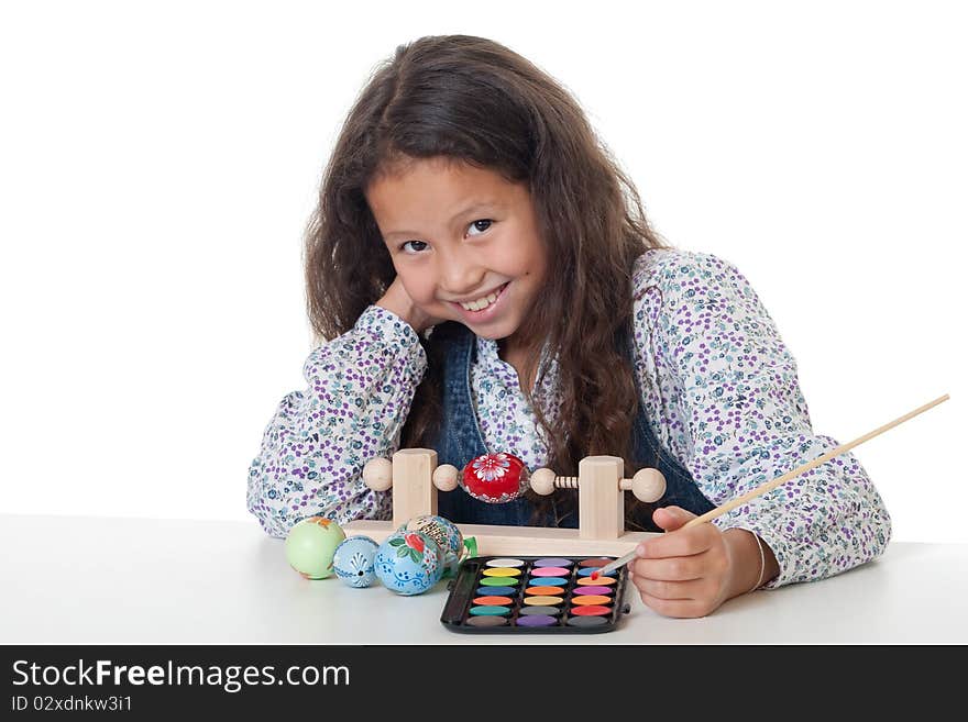 Paint easter egg, girl doing her creative hobby against white background