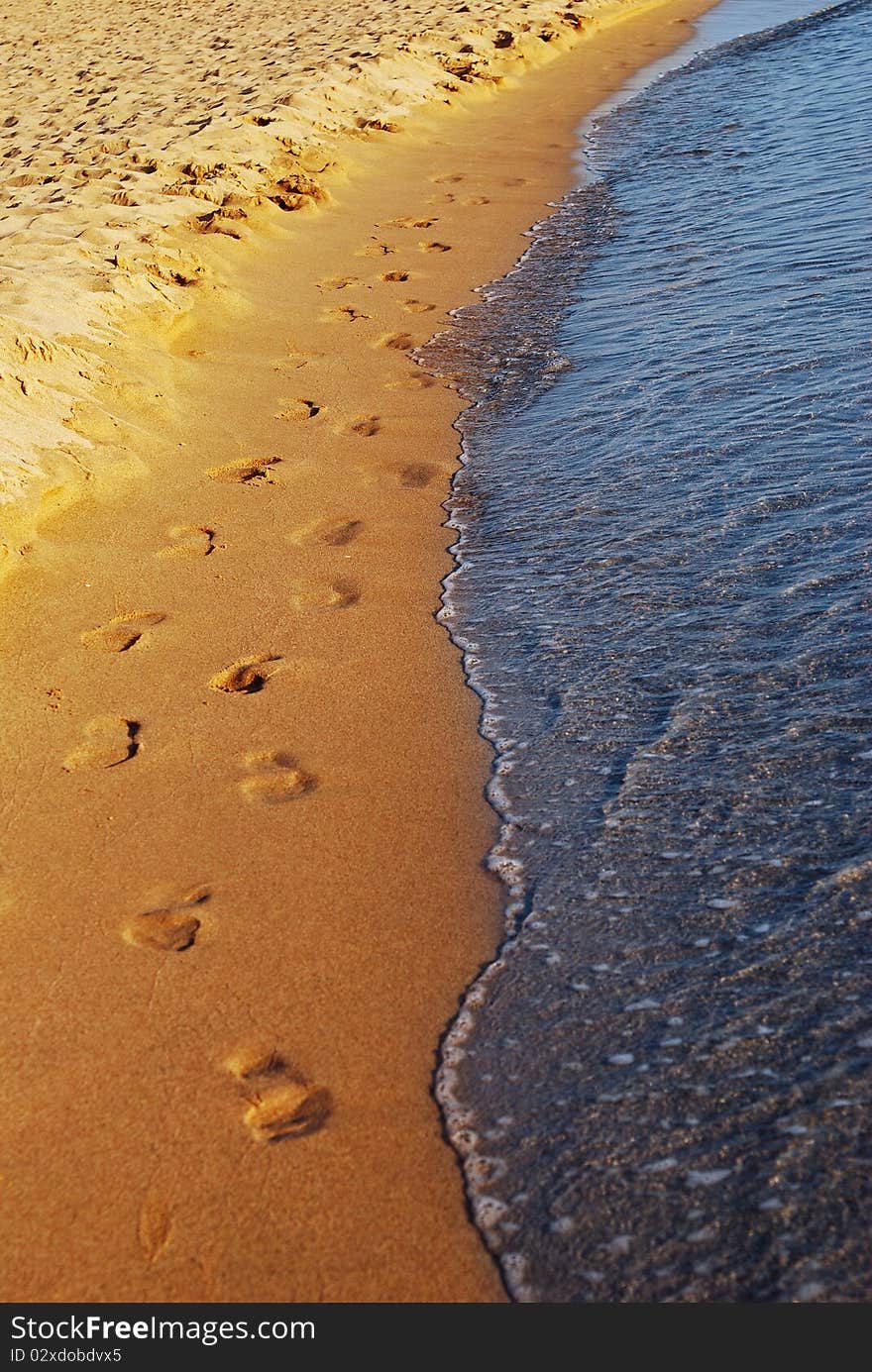 Footprint on sand and wave. Footprint on sand and wave