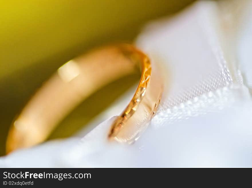 Classic gold wedding ring on white satiny fabric. Classic gold wedding ring on white satiny fabric