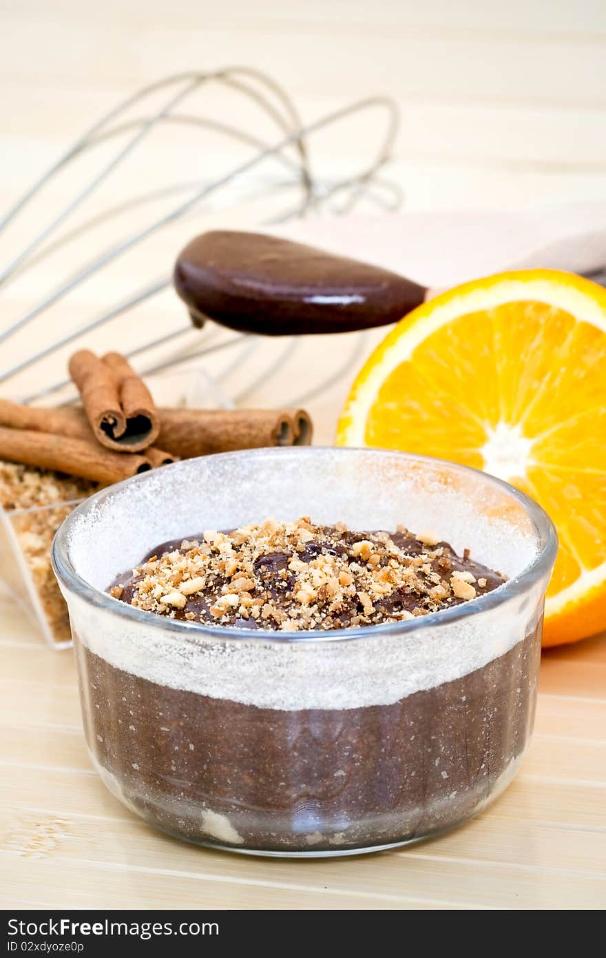 Chocolate cake surrounded by the ingredients, including chocolate, cinnamon, and a sliced orange. Chocolate cake surrounded by the ingredients, including chocolate, cinnamon, and a sliced orange.