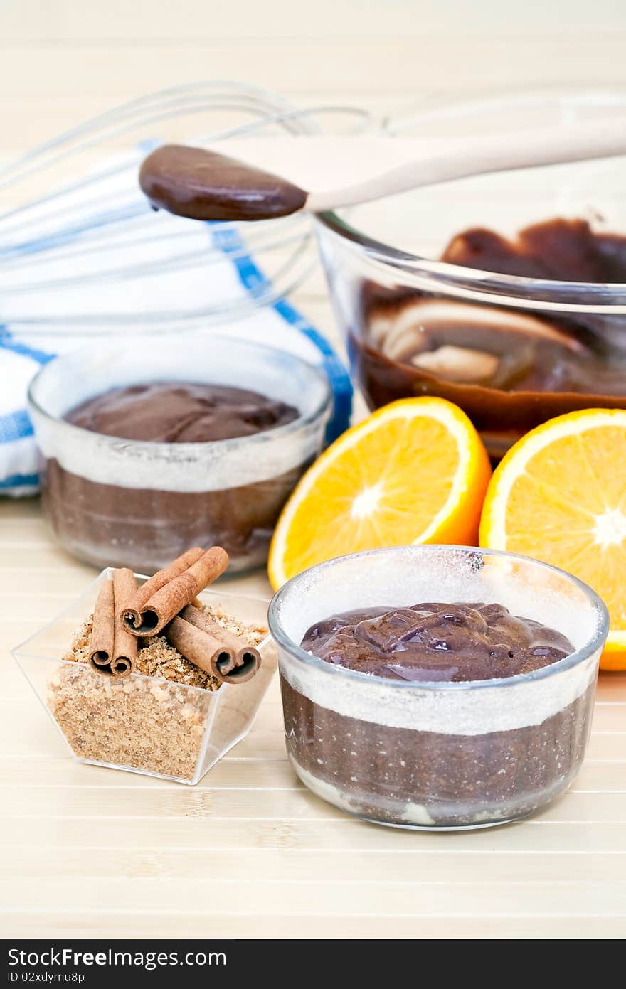 Chocolate cake surrounded by the ingredients, including chocolate, cinnamon, and a sliced orange. Chocolate cake surrounded by the ingredients, including chocolate, cinnamon, and a sliced orange.