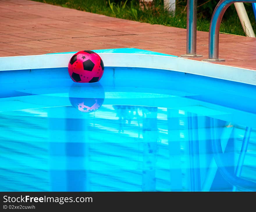 Red ball is floating in blue swimming pool. Red ball is floating in blue swimming pool