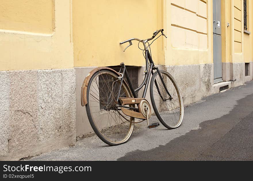 An old broken bicycle in the street. An old broken bicycle in the street