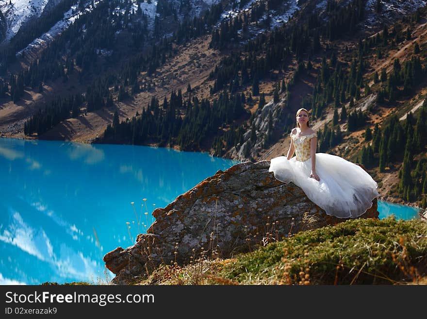 The girl in a wedding dress at mountain lake