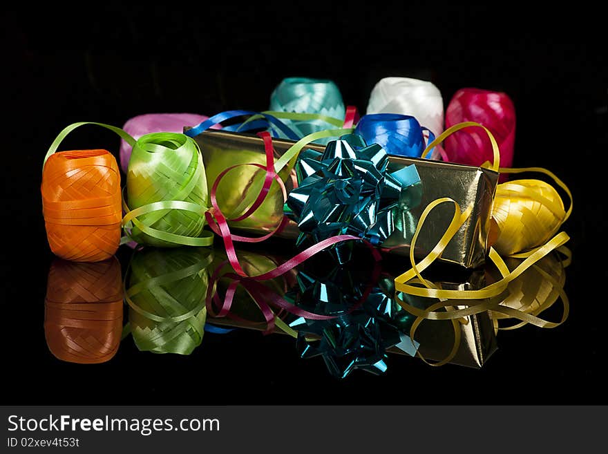 Set of colourful ribbons and a christmas  gift on the black background