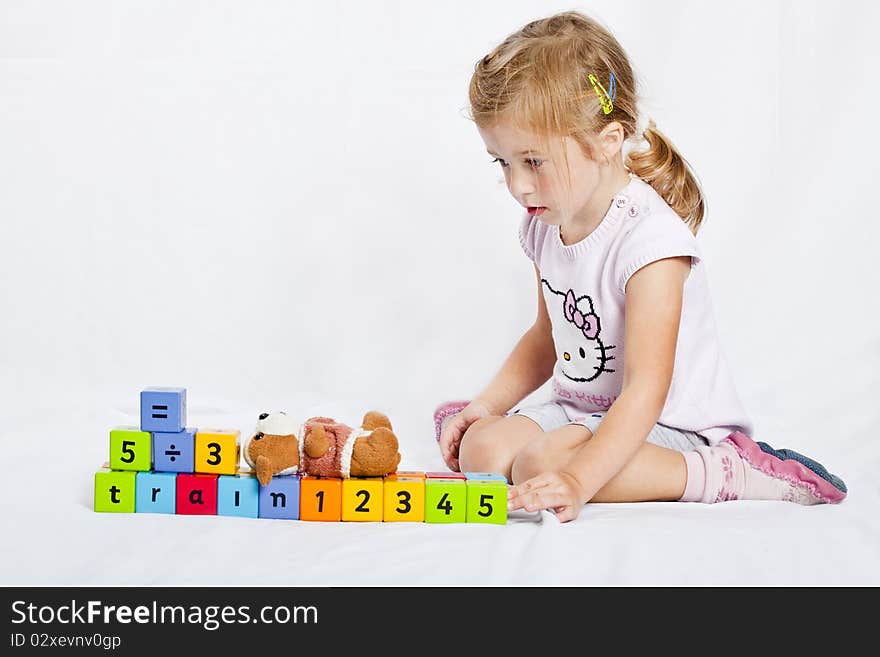 Happy  girl playing with colourful wooden blocks