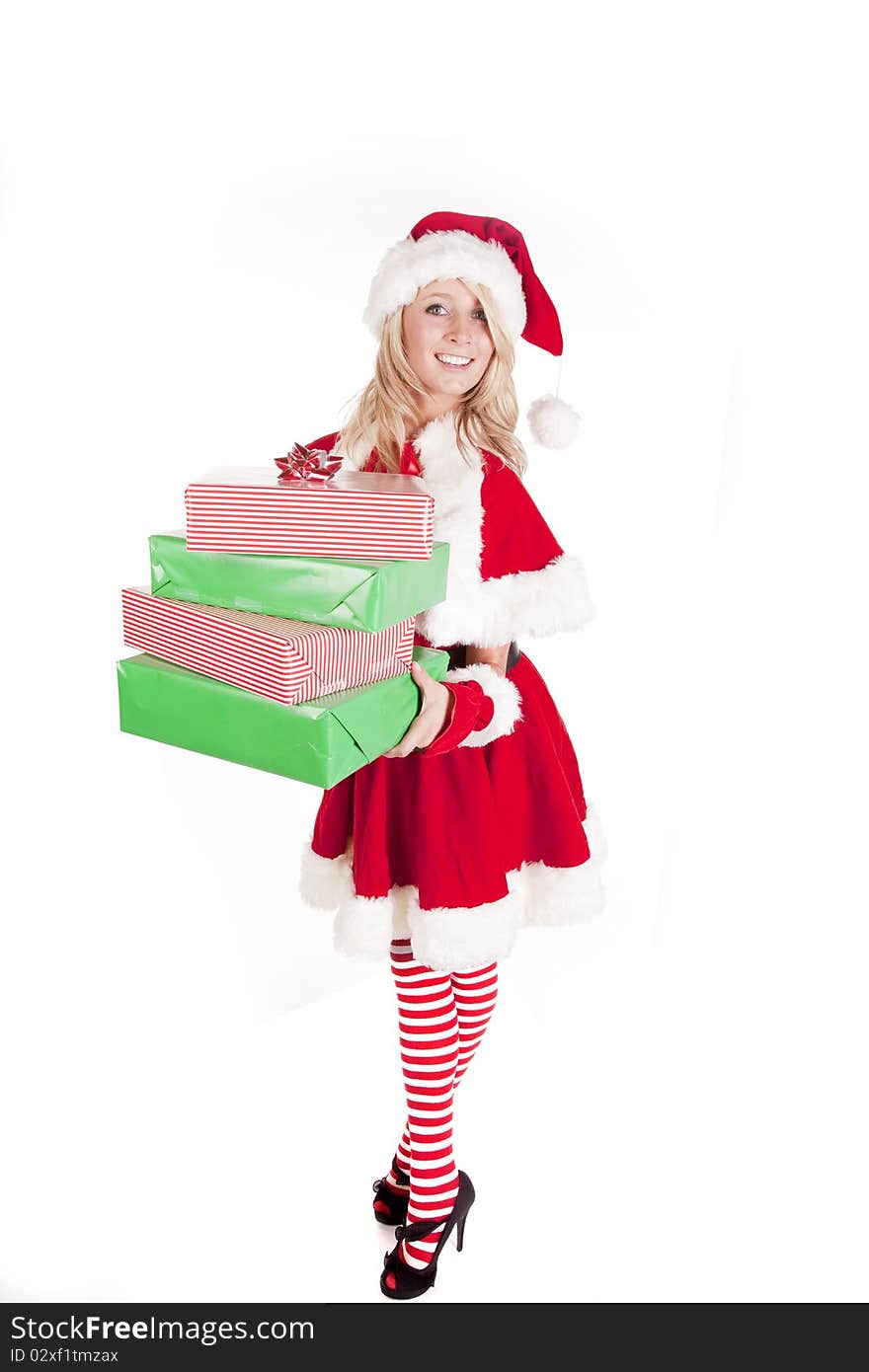 A female dressed like santa holding some presents. A female dressed like santa holding some presents.