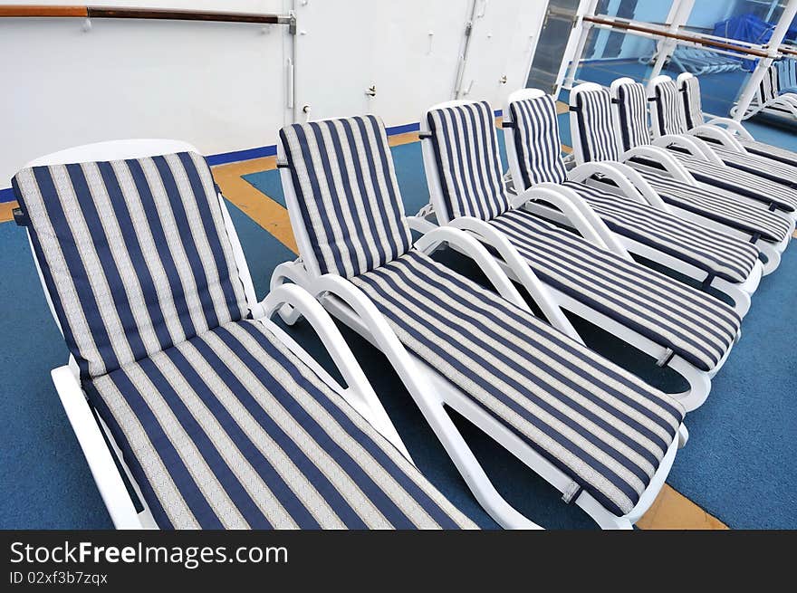 Row of blue beach chairs on cruise ship deck. Row of blue beach chairs on cruise ship deck