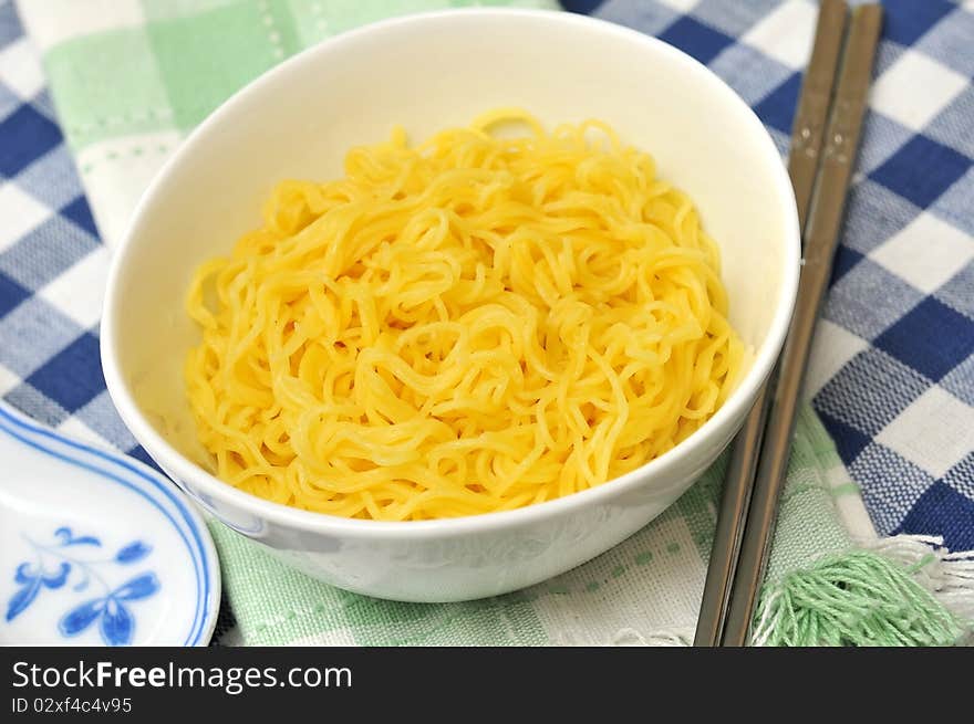 Generic yellow noodles with eating utensils.