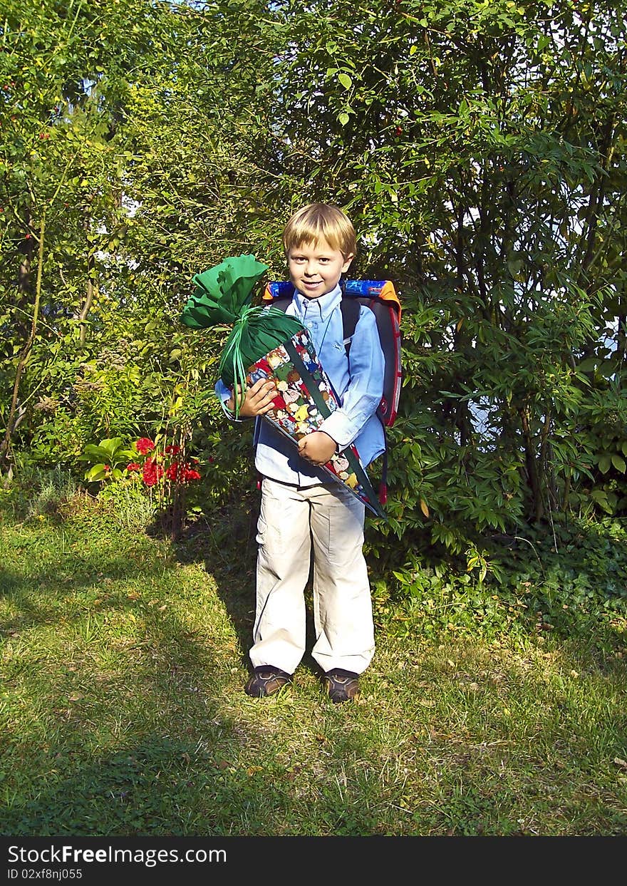 Child is proud of his large cornet of cardboard filled with sweets and little presents given to children in Germany on their first day at school. Child is proud of his large cornet of cardboard filled with sweets and little presents given to children in Germany on their first day at school