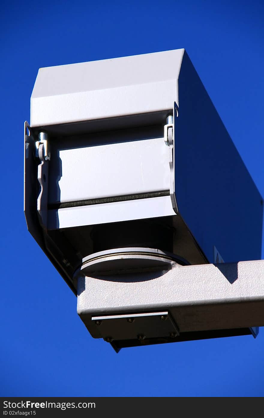 Image of a security camera with a blue sky in the backgrownd. Image of a security camera with a blue sky in the backgrownd