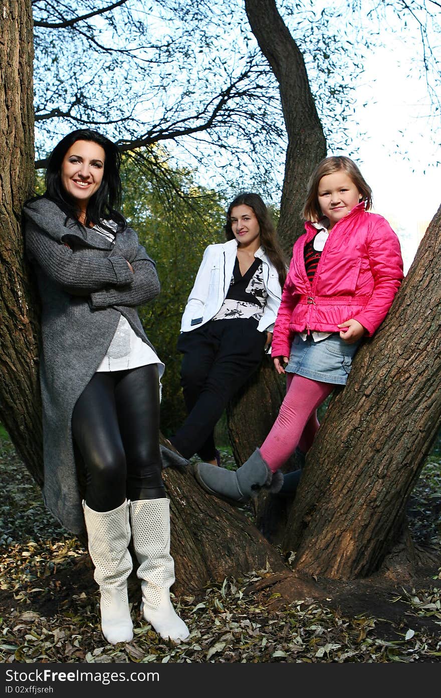 Young family taking healthy stroll through autumn park and have fun