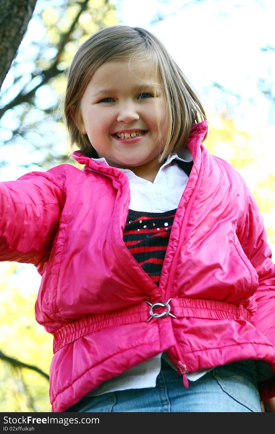 Young family taking healthy stroll through autumn park and have fun