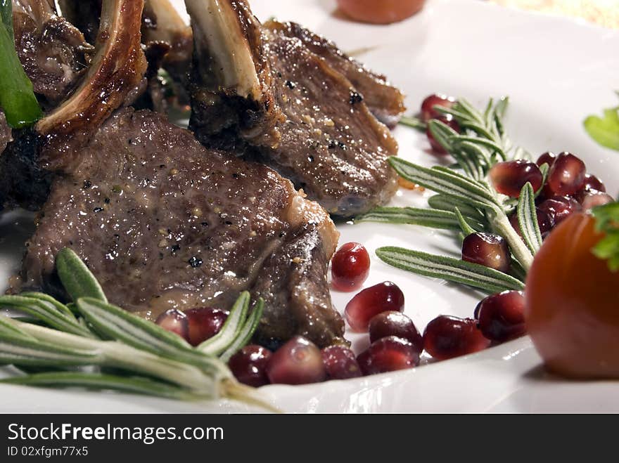 Fried rib served with pomegranate and salad. Fried rib served with pomegranate and salad