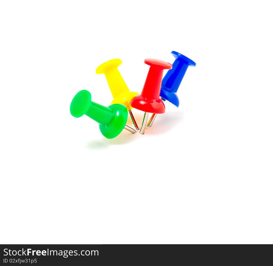 Colorful push pins arranged on white background