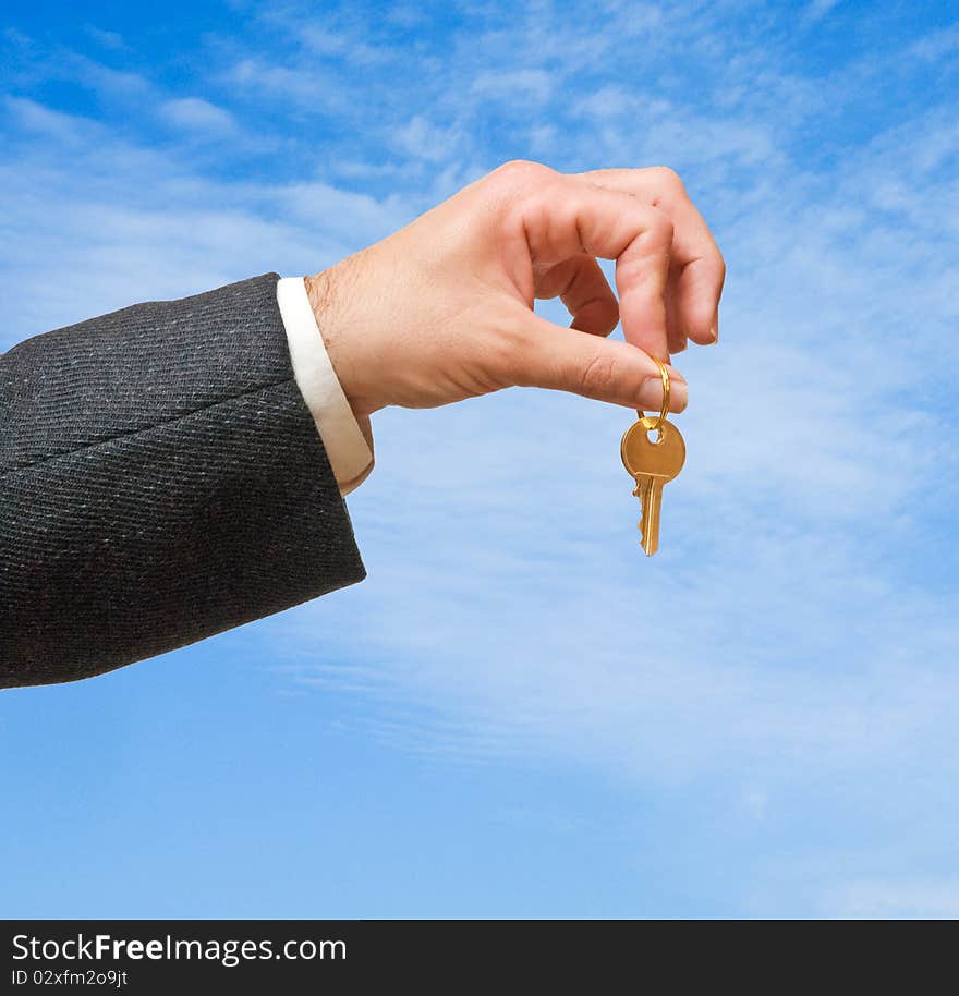 Close up of hand holding key on sky background. Close up of hand holding key on sky background