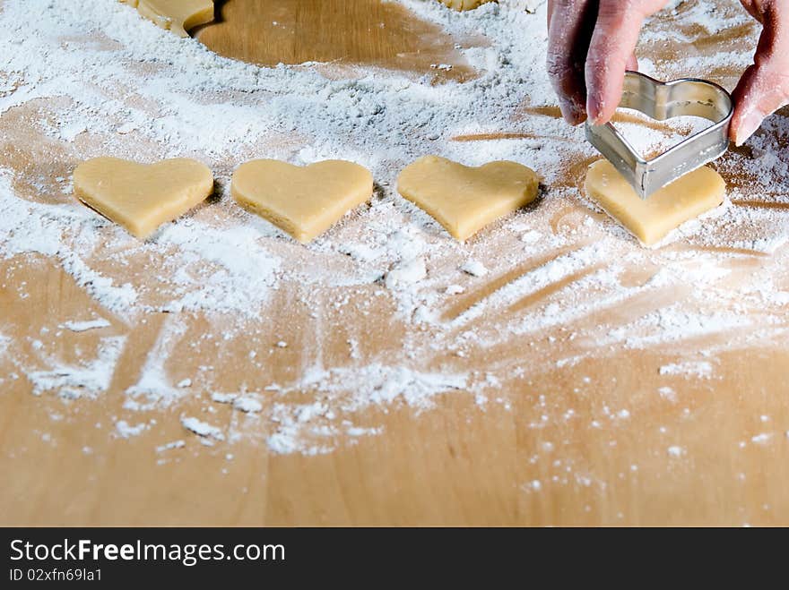 Heart ramekins are gouged in the dough. Heart ramekins are gouged in the dough