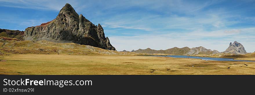 Panorama of Anayet peak in Spanich Aragon and Peak du Midi d'Ossau in French Bearn in Pyrenees mountains, seen from plateau Anayet in summer time. Panorama of Anayet peak in Spanich Aragon and Peak du Midi d'Ossau in French Bearn in Pyrenees mountains, seen from plateau Anayet in summer time