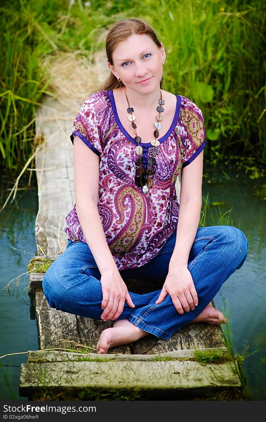 Portrait of beautiful happy pregnant woman on meadow