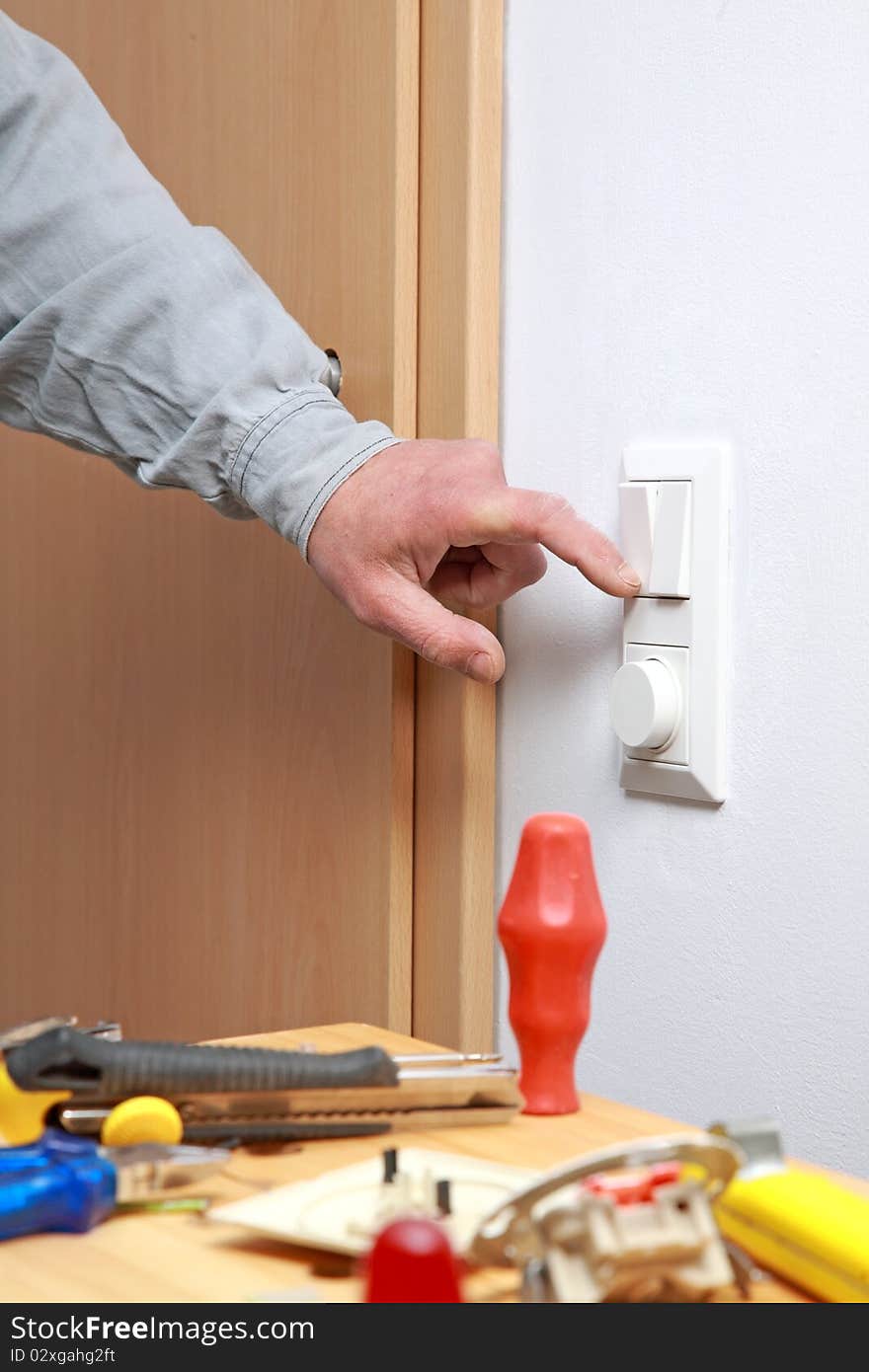 Electrician installing dimmer and a light switch. Electrician installing dimmer and a light switch.