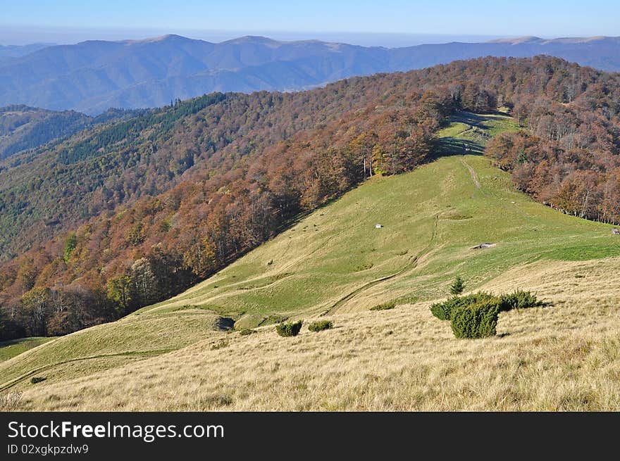 Autumn hillsides in a landscape under the dark blue sky. Autumn hillsides in a landscape under the dark blue sky.