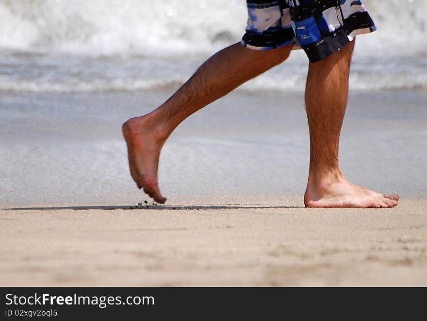 Man walks along the Kuta beach in Bali. Man walks along the Kuta beach in Bali