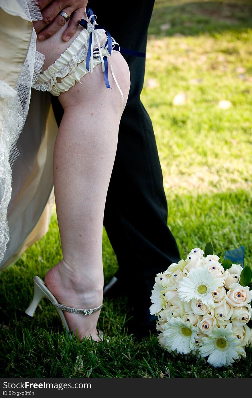 Groom’s hand on bride s leg with blue garter