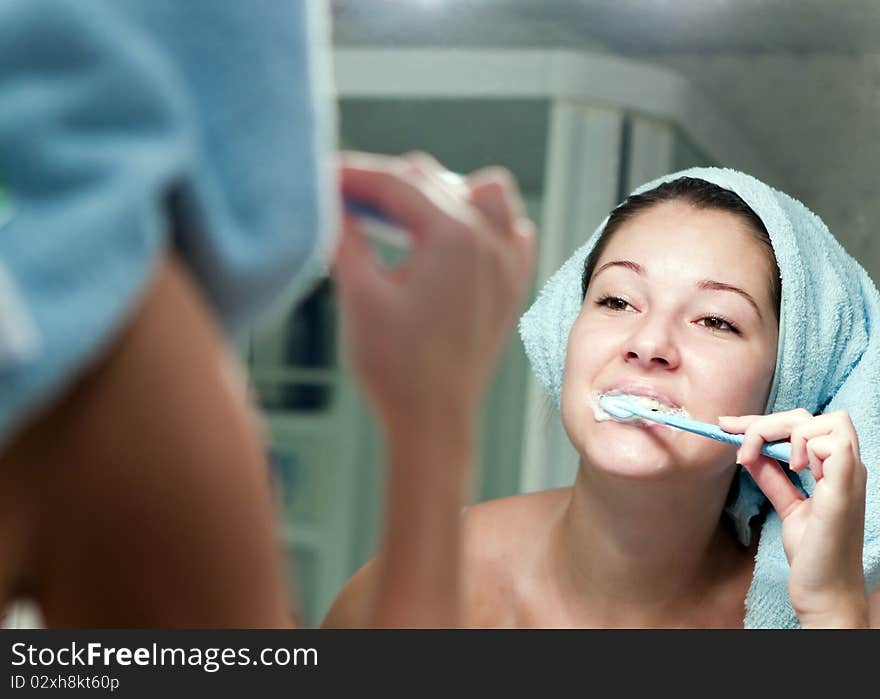 Girl carefully brushing his teeth in the mirror. Girl carefully brushing his teeth in the mirror