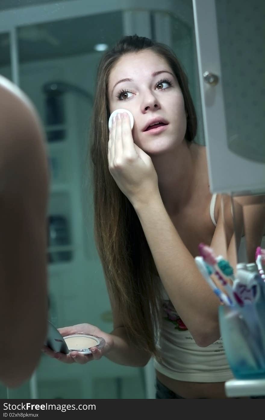 The girl does makeup in the bathroom