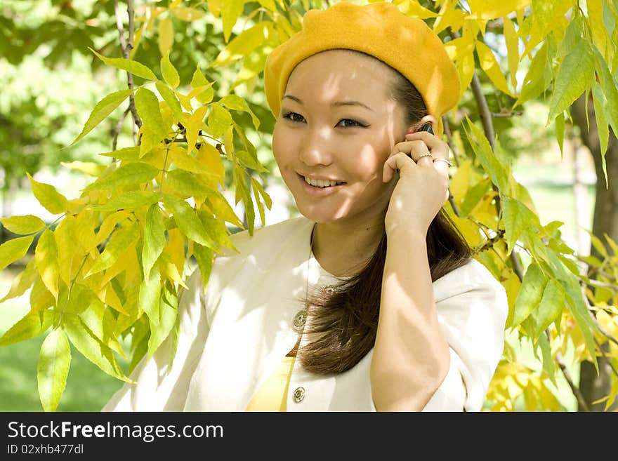 Girl talking by phone in autumn park