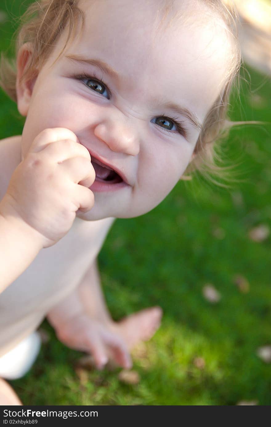 Pretty smilling little girl sitting outdoors. Pretty smilling little girl sitting outdoors