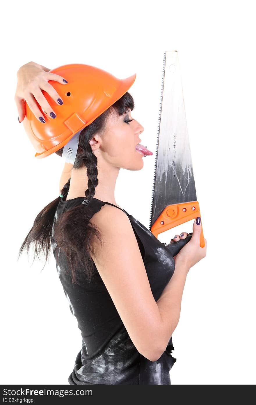 Girl in an orange hard hat licks a saw. Girl in an orange hard hat licks a saw