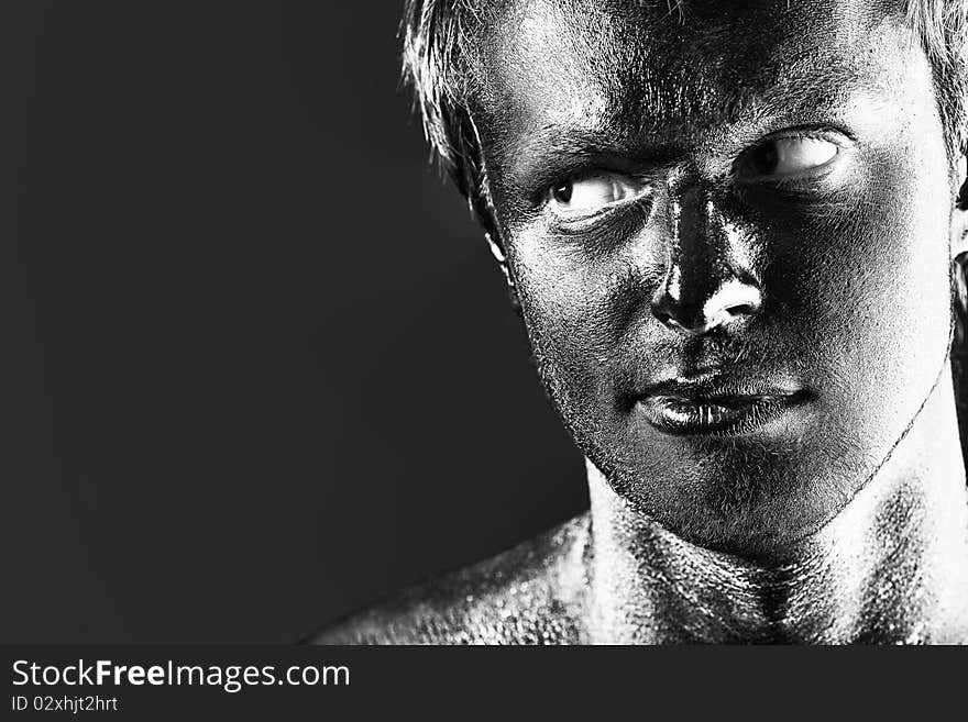 Portrait of expressive man painted with black color. Body painting project. Portrait of expressive man painted with black color. Body painting project.