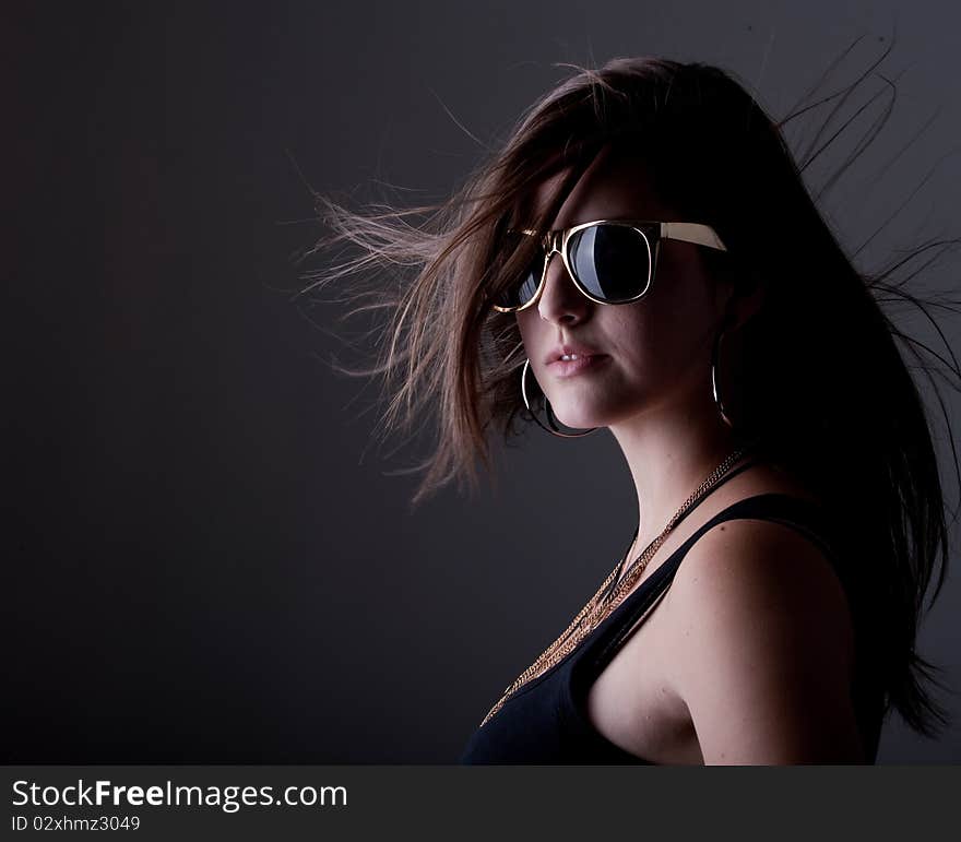 Young stylish teenage girl over black background with nice long hair. Young stylish teenage girl over black background with nice long hair.