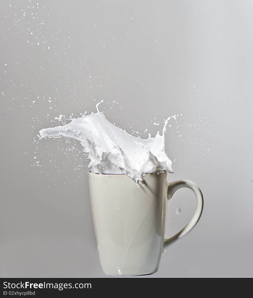 Exploding glass of milk with droplets in the air