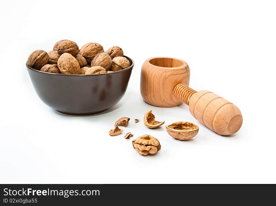 Nut cracker with walnuts in brown bowl and cracked nut. Nut cracker with walnuts in brown bowl and cracked nut