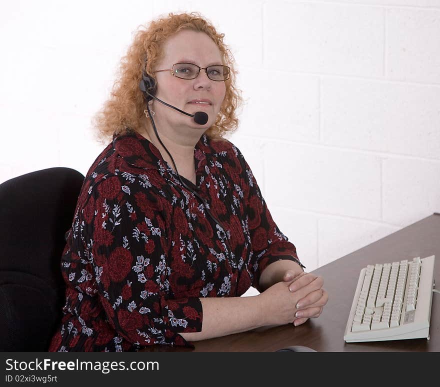 Productive middle aged woman working in a call center. Productive middle aged woman working in a call center