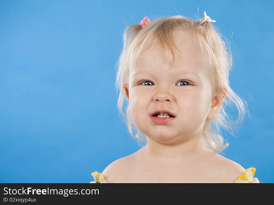 Small lovely girl on a blue background.