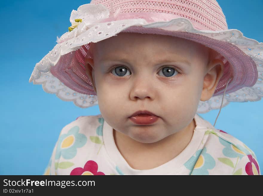 Child in the big hat on a blue background. Child in the big hat on a blue background