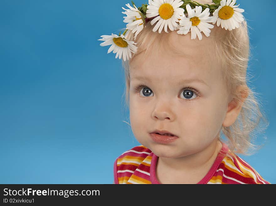 Beautiful little girl the blonde on a blue background. Beautiful little girl the blonde on a blue background