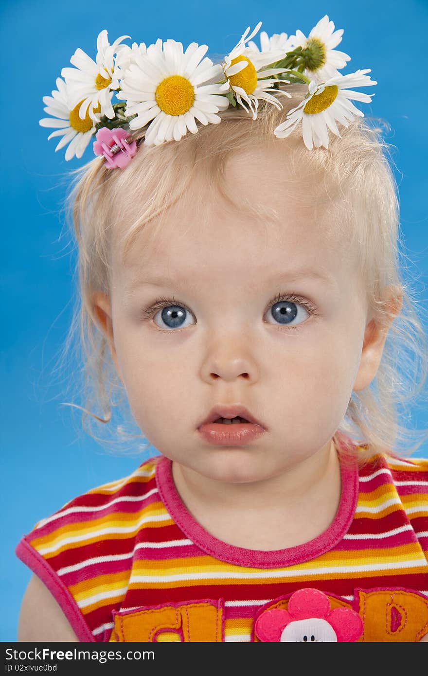 Beautiful little girl the blonde on a blue background. Beautiful little girl the blonde on a blue background